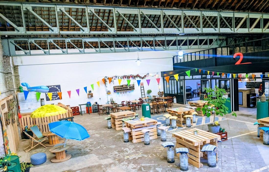 Vue intérieure de la Brasserie de Mai, grande salle décorée à l'année avec bar au fond