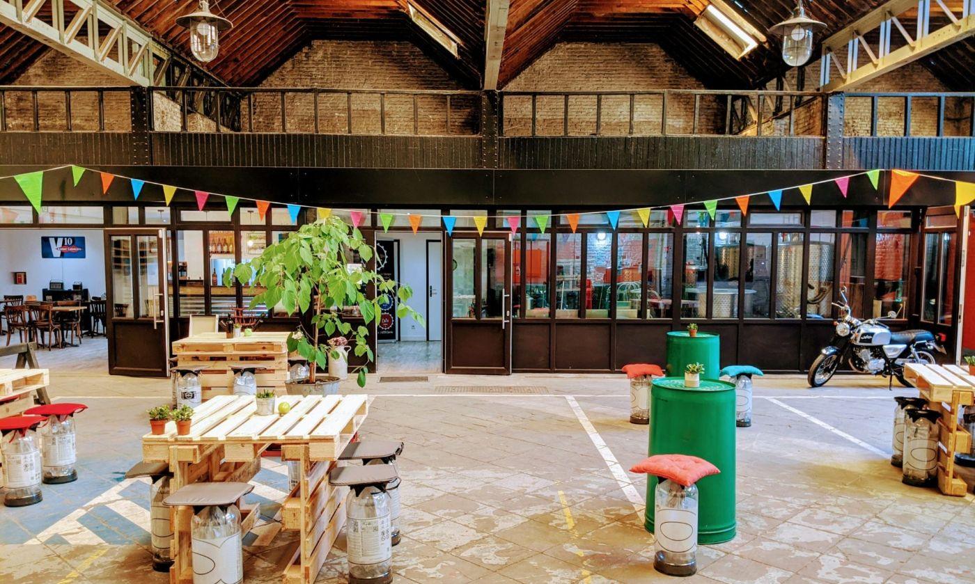 Intérieur de la Brasserie de Mai, charpente en bois et guirlandes de fanions